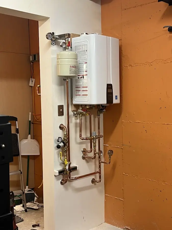 Plumbing technician inspecting water heater connections in Swannanoa
